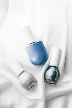 Nail polish bottles on silk background, french manicure products and nailpolish make-up cosmetics for luxury beauty brand and holiday flatlay art design
