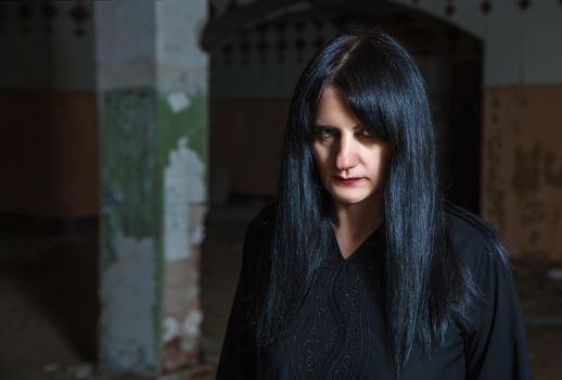 portrait of young goth woman in an abandoned building