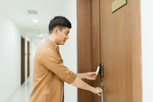 Asian man hand holding Access card / Key Card eletronic door accessing control scanning to lock and unlock door