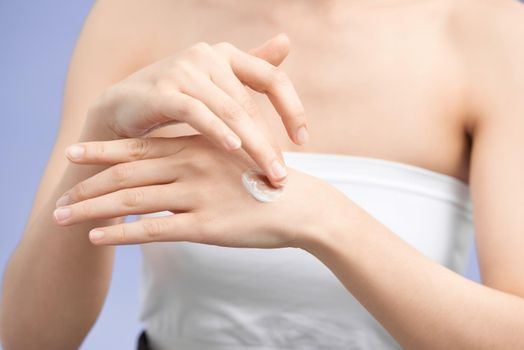 female hands applying hand cream