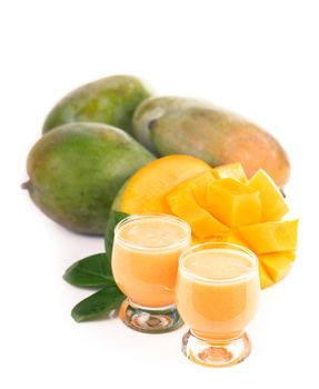 exotic juicy mango fruits and two glasses of fresh natural mango juice isolated on white background
