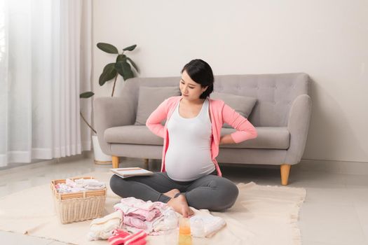Pregnant woman is getting ready for the maternity hospital, packing baby clothes
