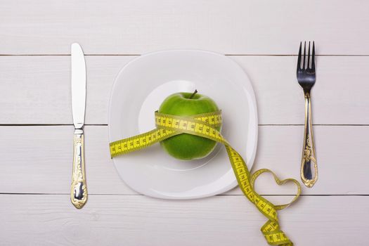 Apple and centimeter on the plate. Sport healthy food.