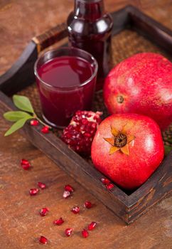 Glass of pomegranate juice on a wooden background.