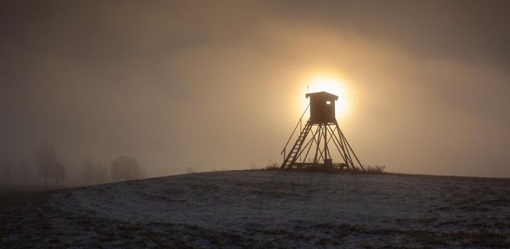 Lookout tower for hunting on the hill at sunrise. 