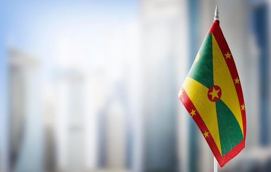A small flag of Grenada on the background of a blurred background