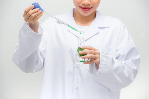 Candid shot of beautiful young Asian female researcher conducting experiment in laboratory,