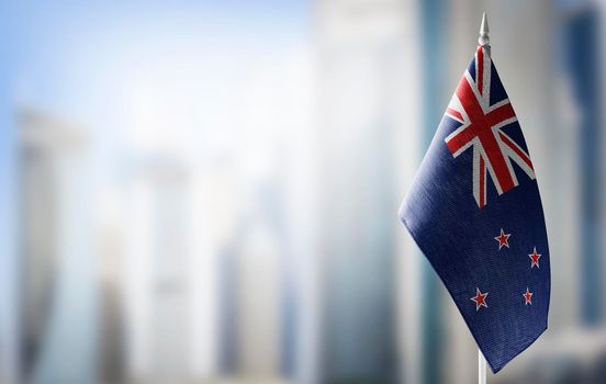 A small flag of New Zealand on the background of a blurred background