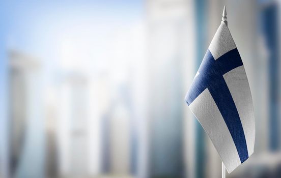 A small flag of Finland on the background of a blurred background
