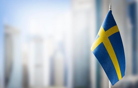 A small flag of Sweden on the background of a blurred background