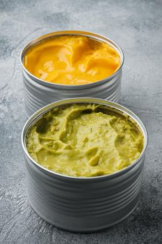 Canned guacamole and cheese dip, on gray background