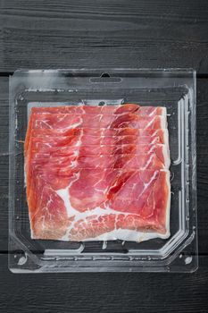Parma ham, on black wooden background, flat lay