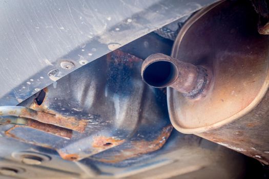 Environmental pollution concept: Close up of old rust eaten exhaust pipe