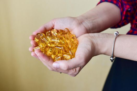 Hands holding fish oil Omega-3 capsules. Medical healthcare, healthy nutrition supplements concept. Vitamin tablets