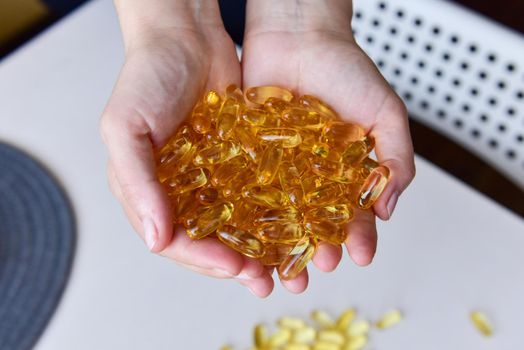 Hands holding fish oil Omega-3 capsules. Medical healthcare, healthy nutrition supplements concept. Vitamin tablets