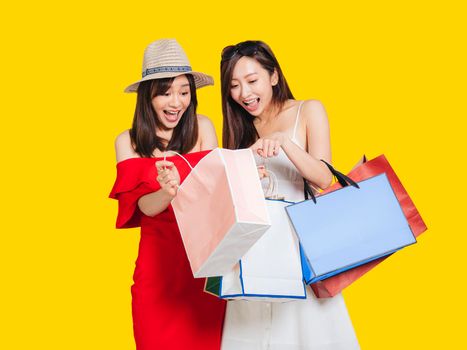 happy young women looking into shopping bags