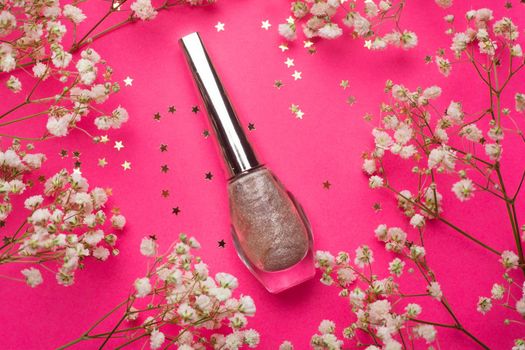 Layout of nail polish and flowers . Nail polish. Painting the nails. Manicure and pedicure. Article about the choice of varnish . The article is about the manicure. Content for a manicurist. Varnish and flowers. Copy space. Photos of the beauty industry for the blog. Pink background