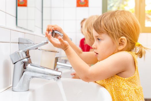 Child in kindergarten washing her hands