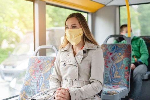 Woman using public transport during covid-19 crisis wearing face mask