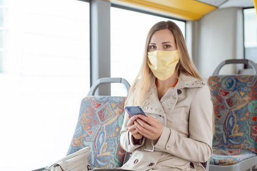 Woman using public transport during covid 19 crisis wearing face mask