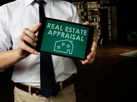 Realtor shows Real estate appraisal on his tablet.
