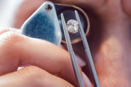 Jeweler looking at precious stone through a loupe