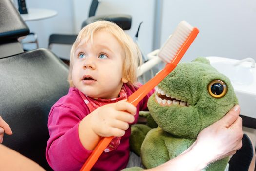 Child at the dentist brushing teeth of a plush toy