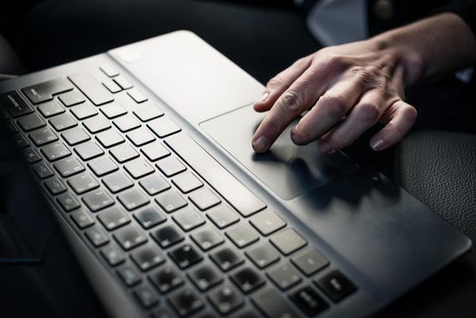Woman's hand using laptop keypad