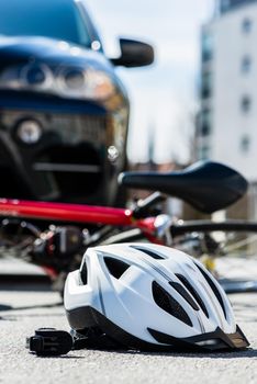 Close-up of a bicycling helmet on the asphalt after car accident