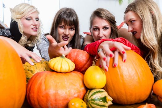 Three women witches joining their malicious forces at Halloween
