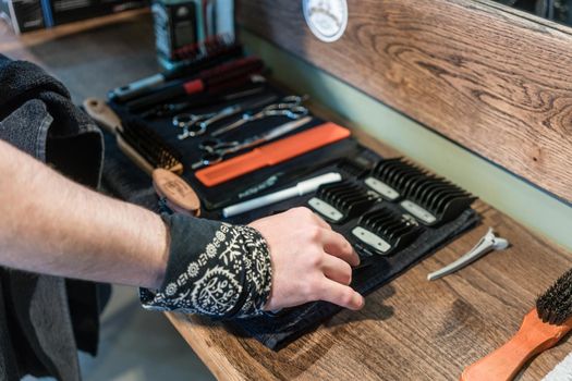 Close-up of the hand of a barber choosing an useful tool
