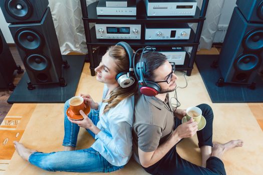 Couple with headphones enjoying music from the Hi-Fi stereo
