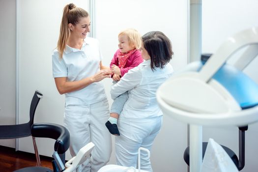 Dentist and her assistant with child in the office