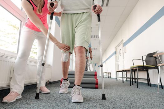 People in rehabilitation learning how to walk with crutches