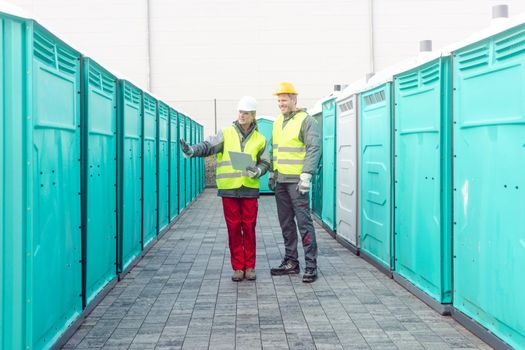 Workers checking the portable toilets for rental
