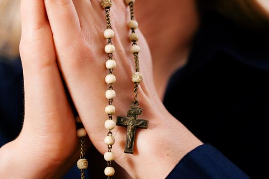 Woman praying with rosary to God