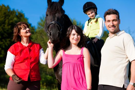 Family and children posing with horse