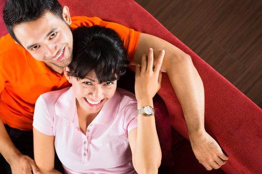 Asian couple at home on sofa