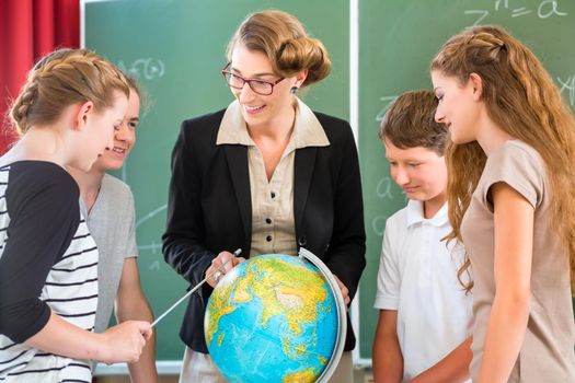 Teacher educate students  having geography lessons in school