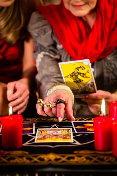Fortuneteller laying Tarot cards with client