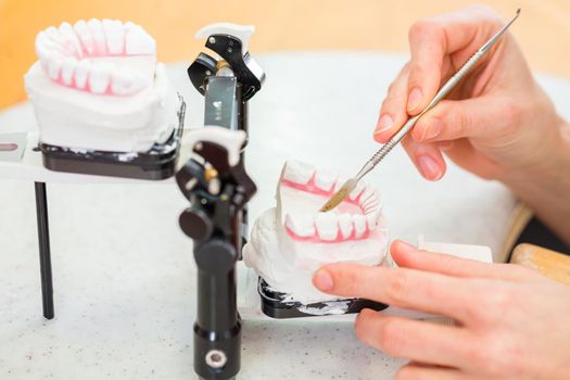 Dental technician producing denture