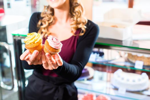 Woman presenting cupcakes of confectionery