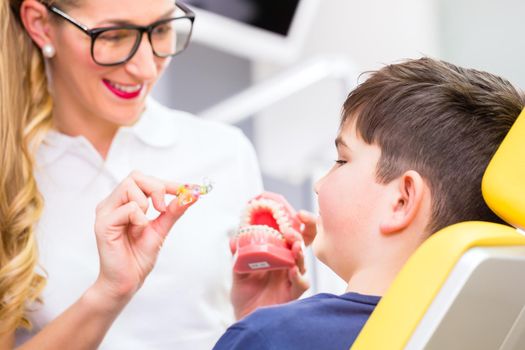 Female Orthodontist explaining boy braces 