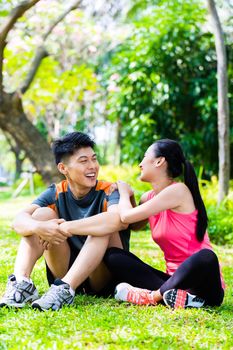Asian couple having break at during sport training