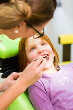 Dentist practicing with child in dental surgery