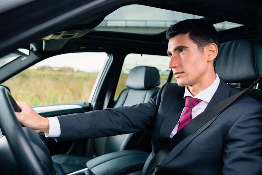 Man driving in his car in business attire