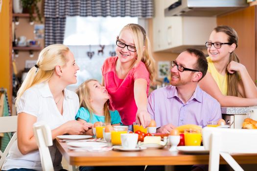 Family having joint breakfast in kitchen