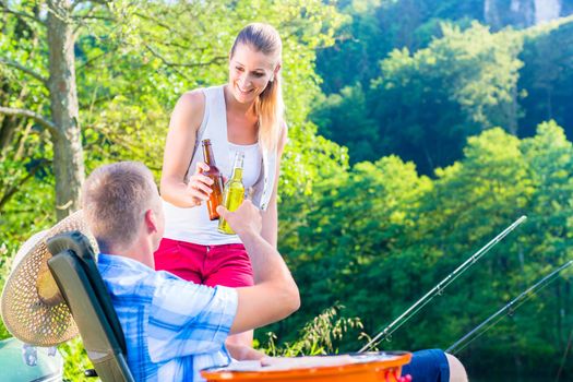Couple of woman and man having beer while sport fishing