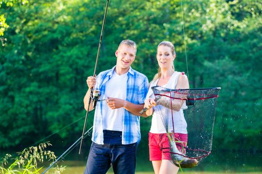 Couple sport fishing bragging with fish caught 