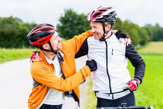 Bicyclists embrace each other in finish celebrating
